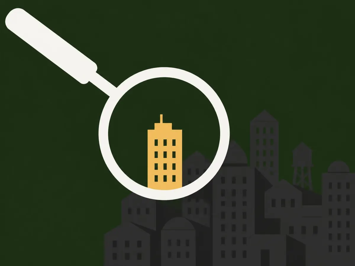 Illustration of a magnifying glass over rooftop buildings, with one building highlighted in gold inside the lens